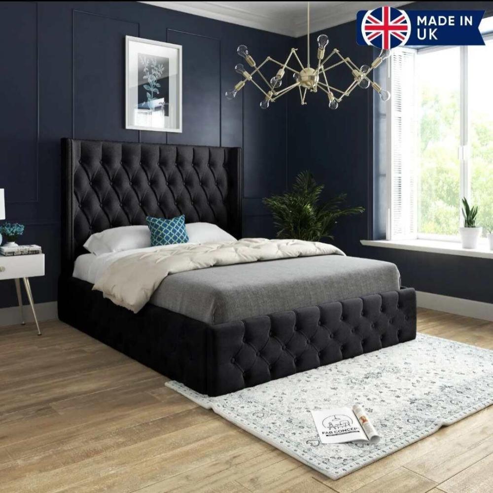 A stylish bedroom with a tufted black Wooden bed Frame, navy blue walls, and gold chandelier, featuring a "MADE IN UK" banner.