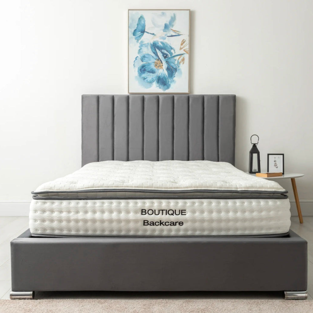 Bedroom with a gray upholstered bed and a memory foam mattress