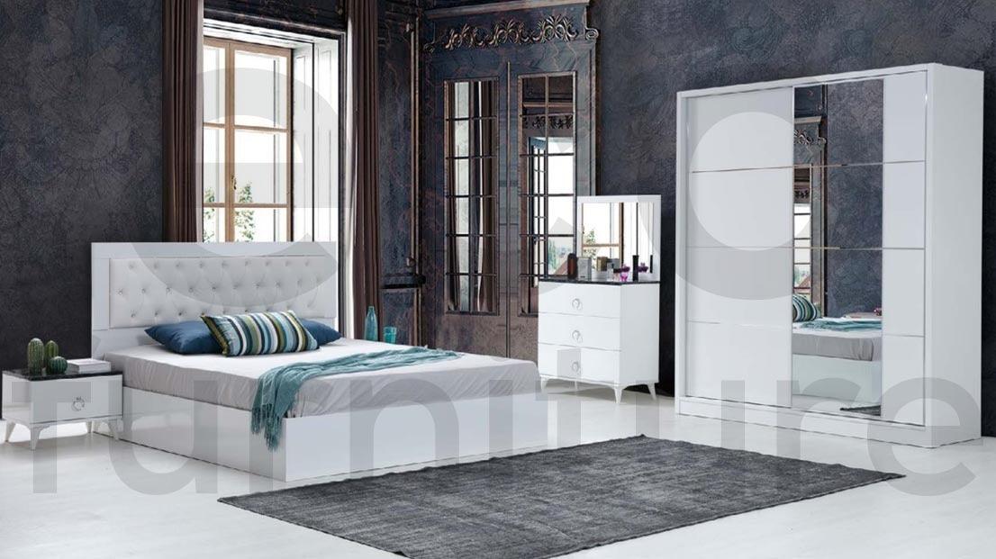 A modern bedroom furniture with a white bed and furniture against a dark wall.