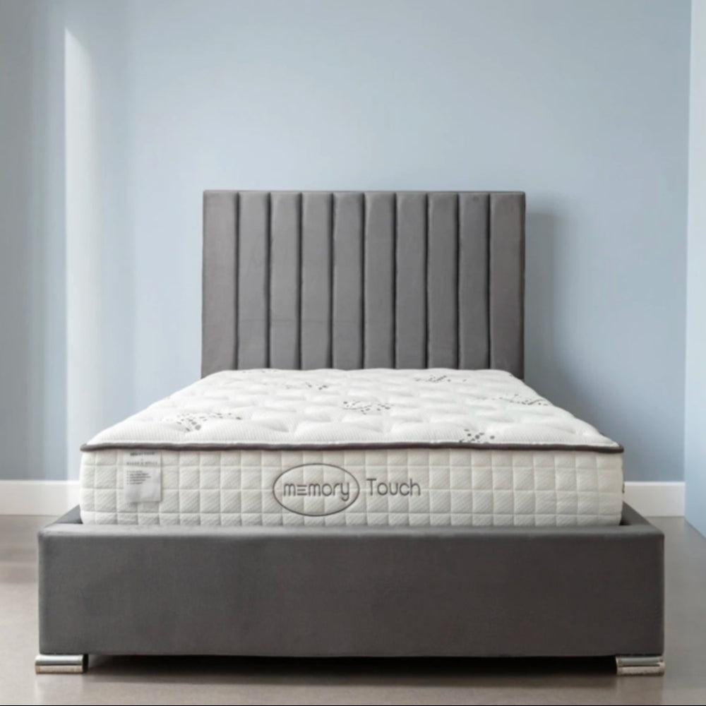 A modern bed with a Memory Touch mattress and a dark gray upholstered frame.