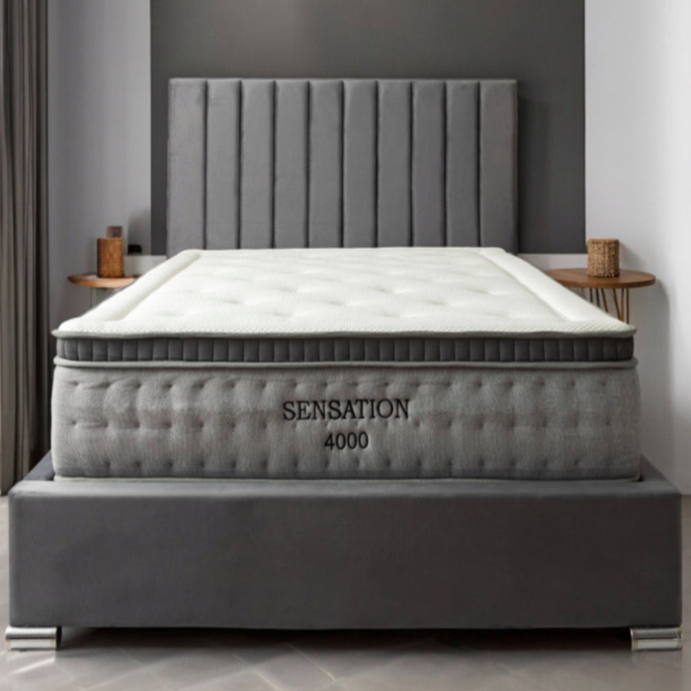 Bedroom with a large bed featuring a "Sensation 4000" mattress with a grey padded headboard.