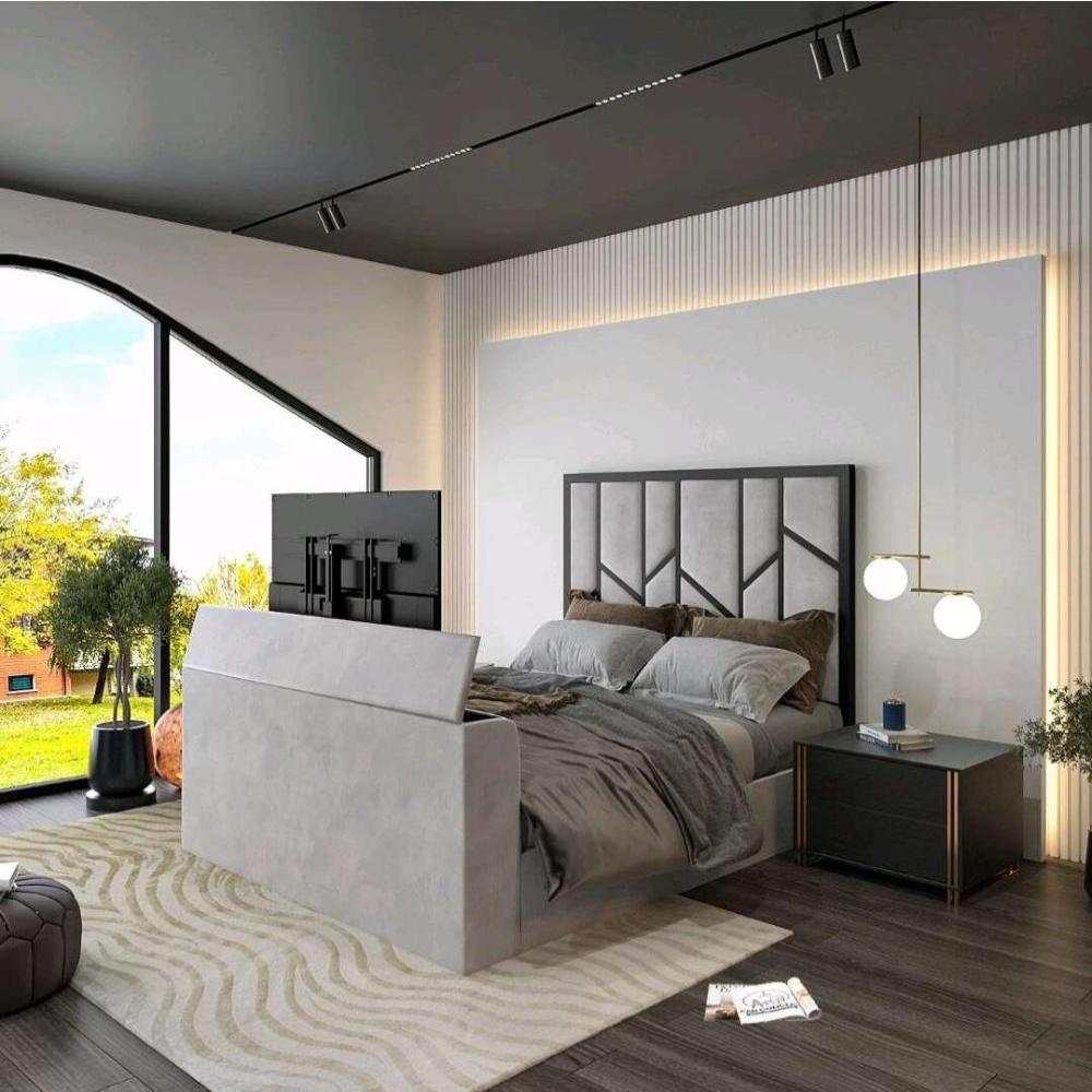 Modern bedroom with a gray upholstered Zig Zag Tv bed, flat-screen TV, black nightstand, and large window view of greenery.

